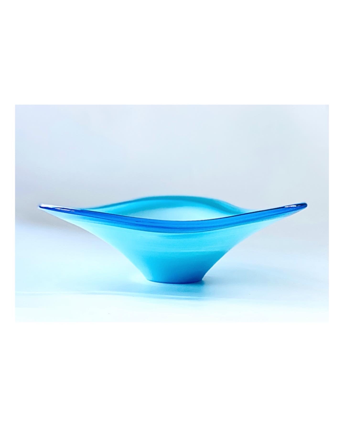 A Murano glass bowl in sky blue with a soft wave and an outer rim in admiral blue.