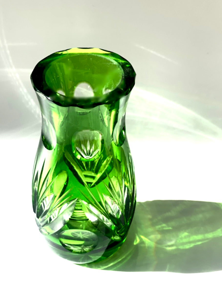 An emerald green crystal cut glass vase .