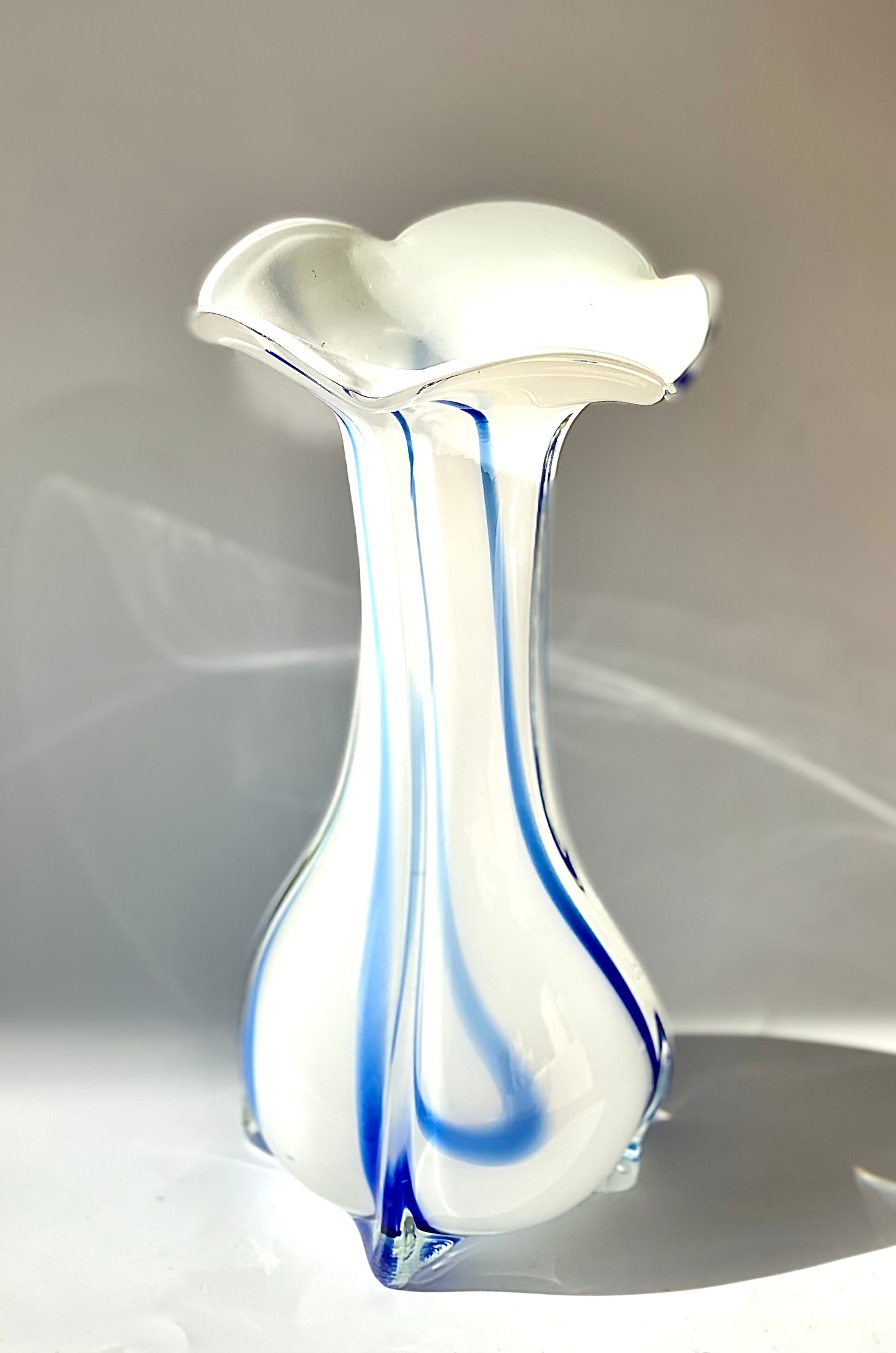 An opaque white glass vase with a Curzon Blue swirl