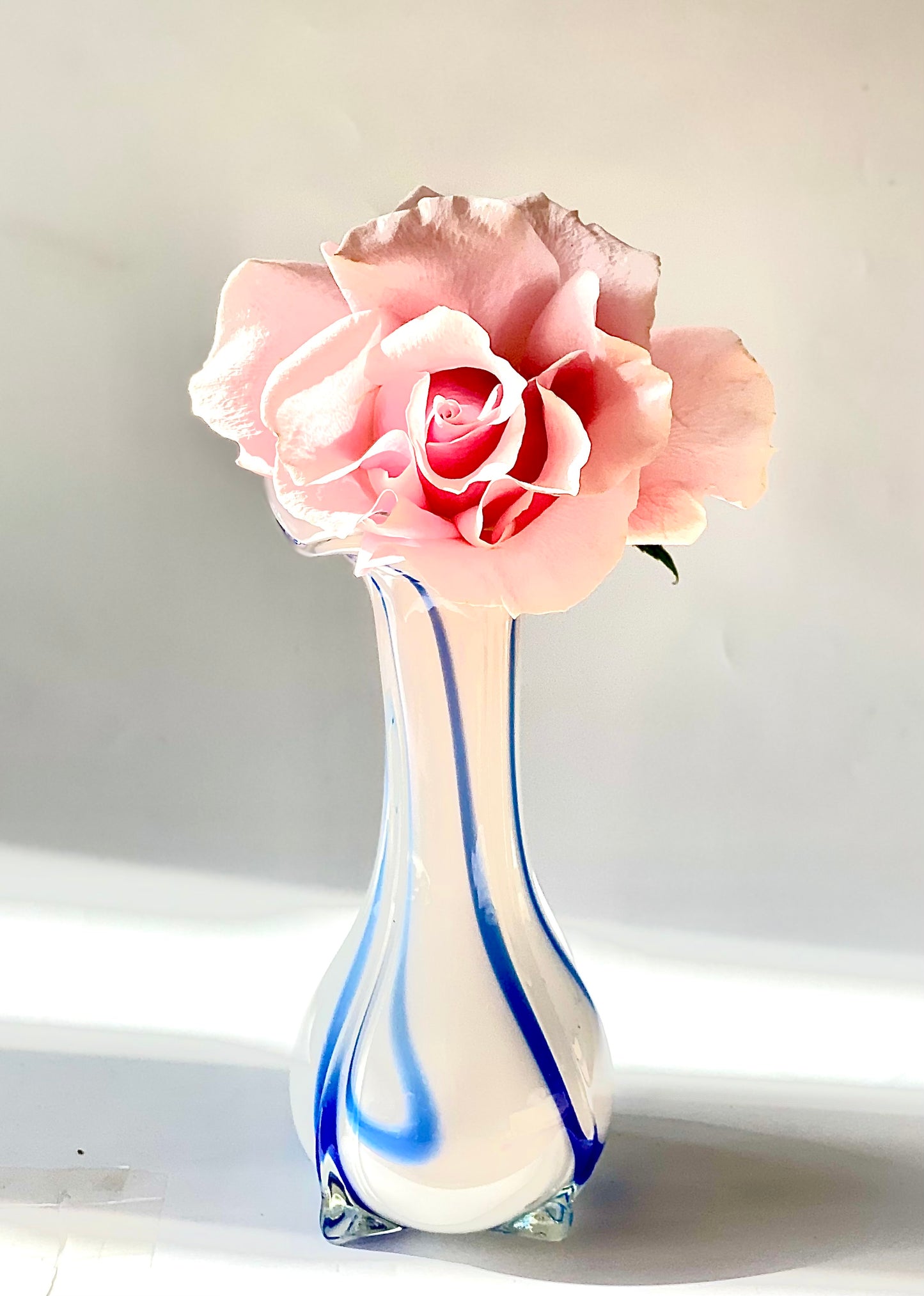 An opaque white glass vase with a Curzon Blue swirl