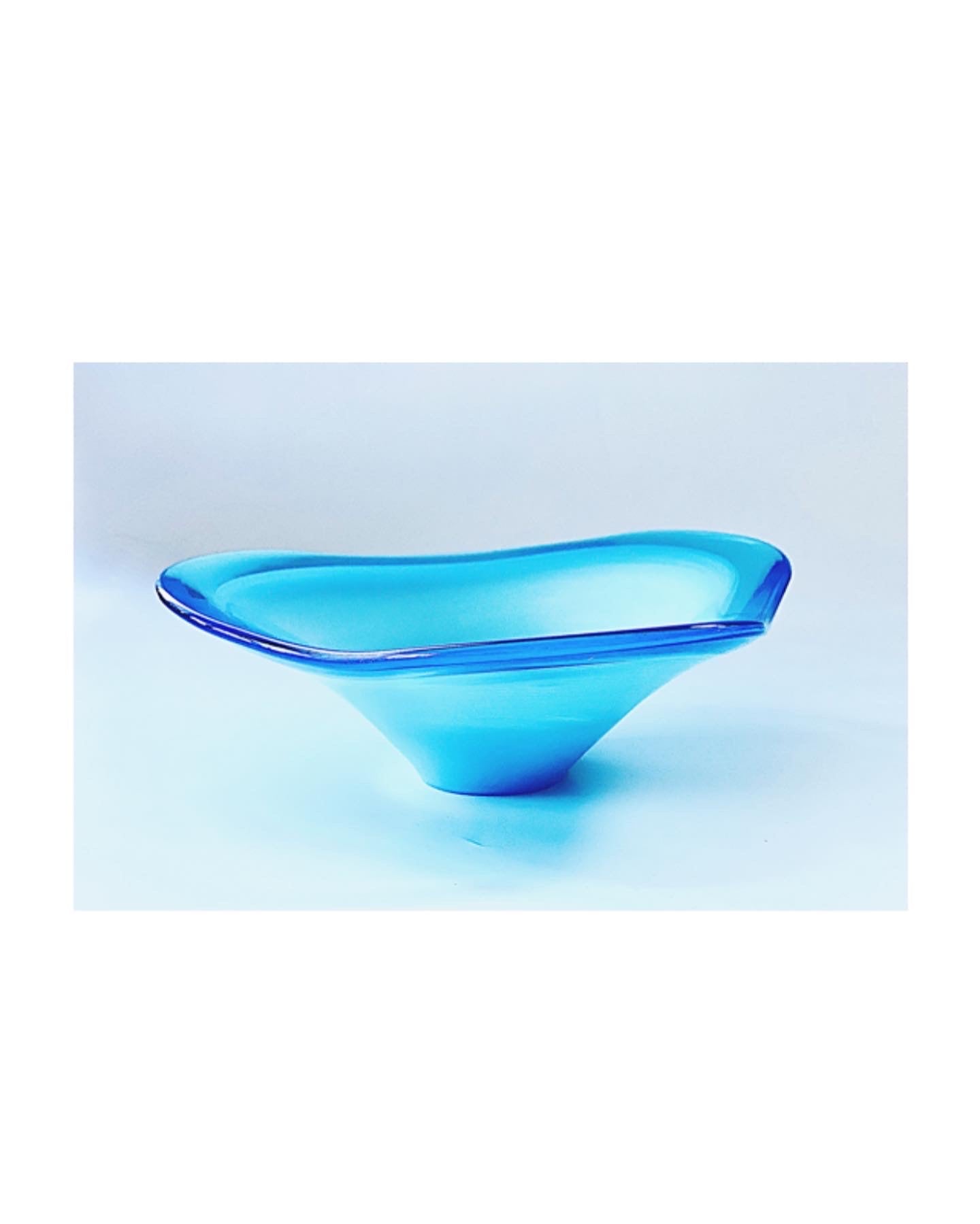 A Murano glass bowl in sky blue with a soft wave and an outer rim in admiral blue.