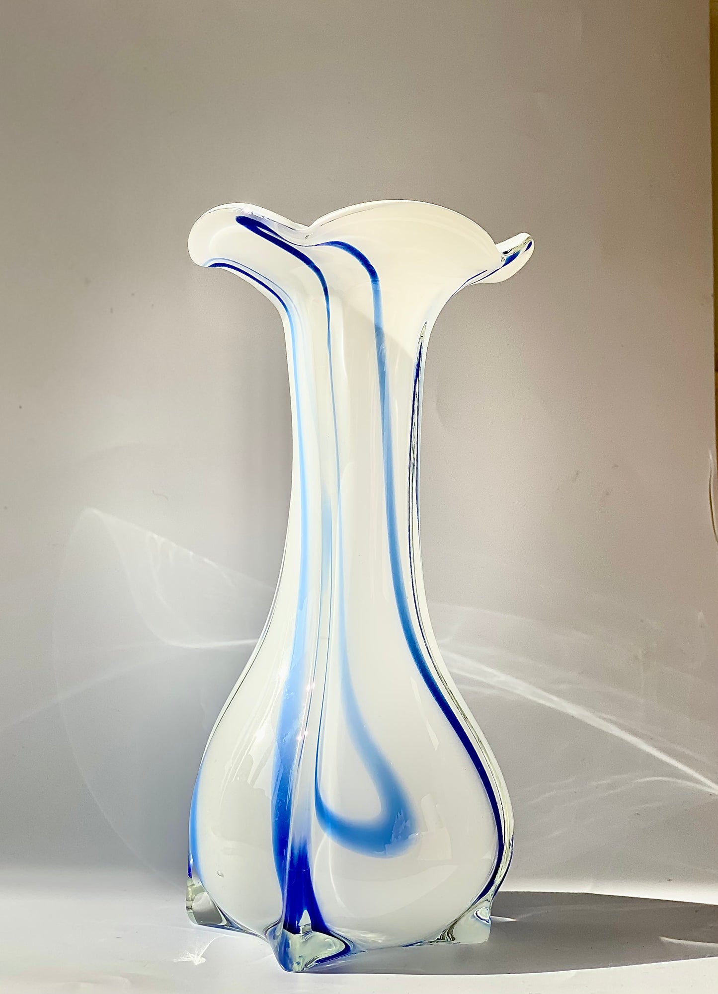 An opaque white glass vase with a Curzon Blue swirl