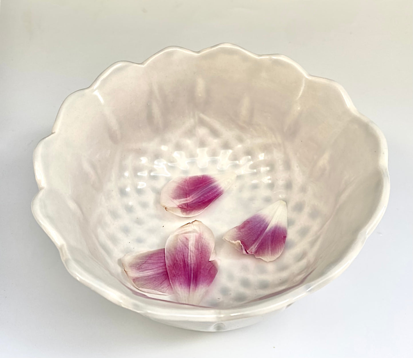 A porcelain bowl with a clear gloss glaze and a scalloped edge.