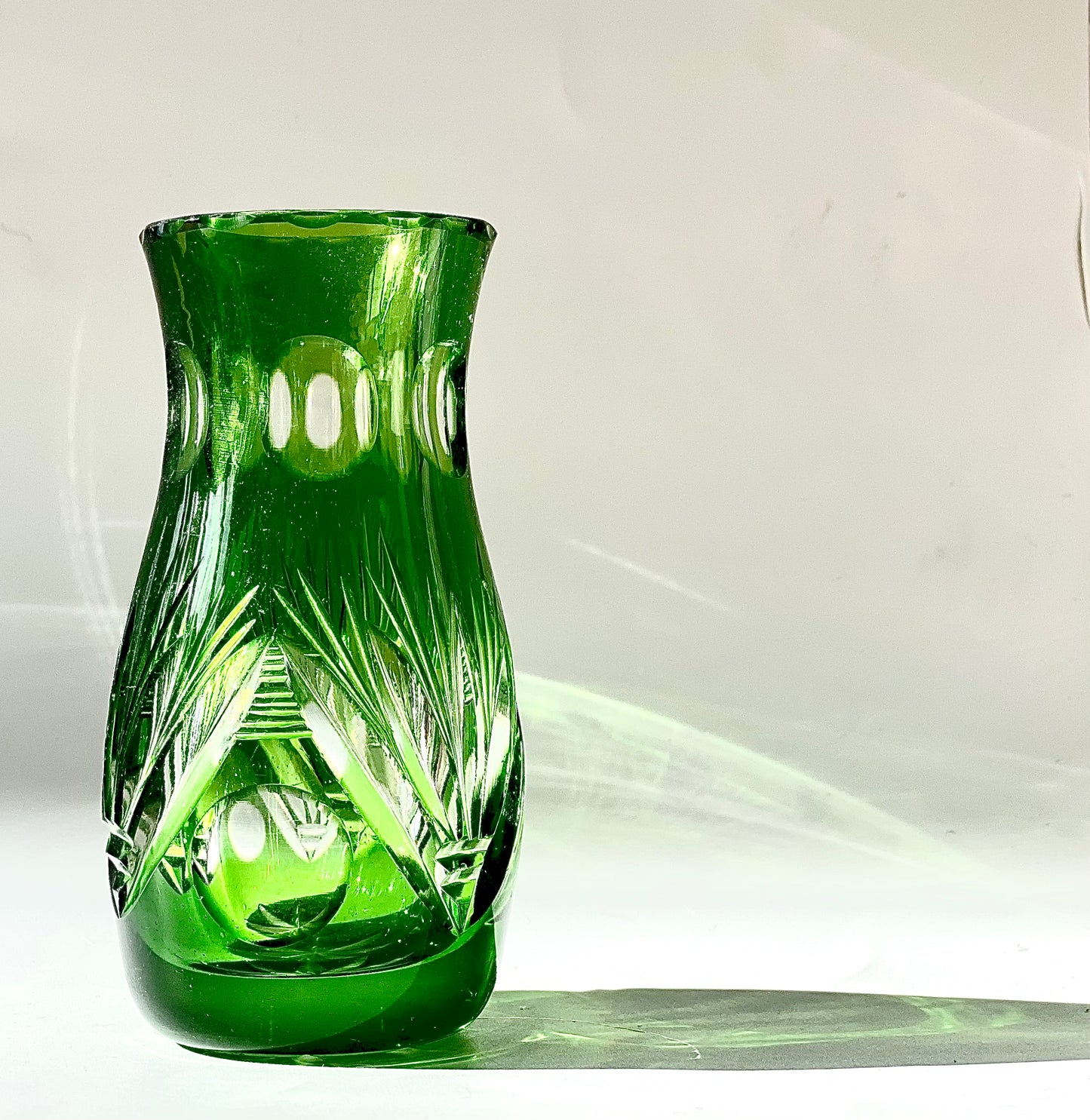 An emerald green crystal cut glass vase .