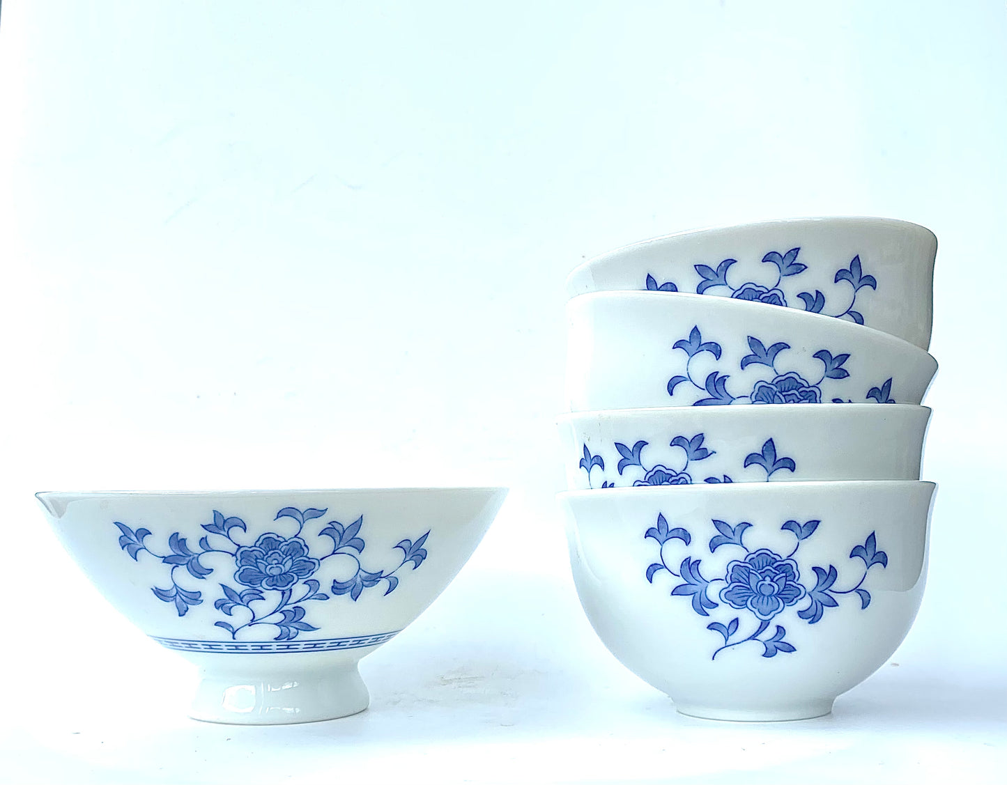 A collection of blue and white ceramic bowls and with one larger one .