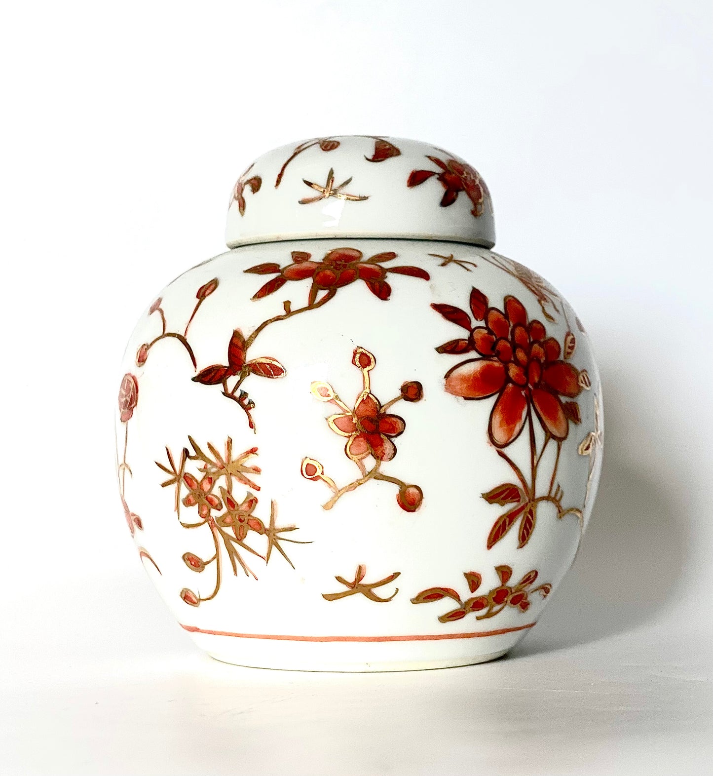 A Ginger jar. With gold gilding and orange flowery designs.