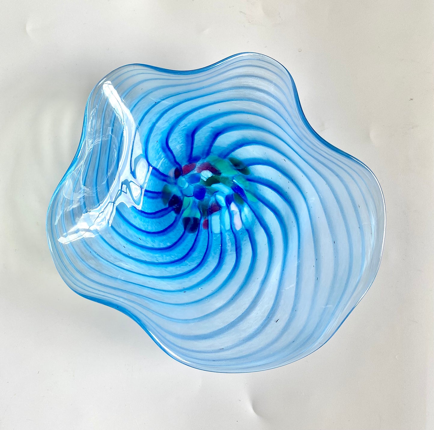 An unusual Murano glass bowl with a charming deep blue swirl and a cluster of pink,blue and green glass fragments in the centre.