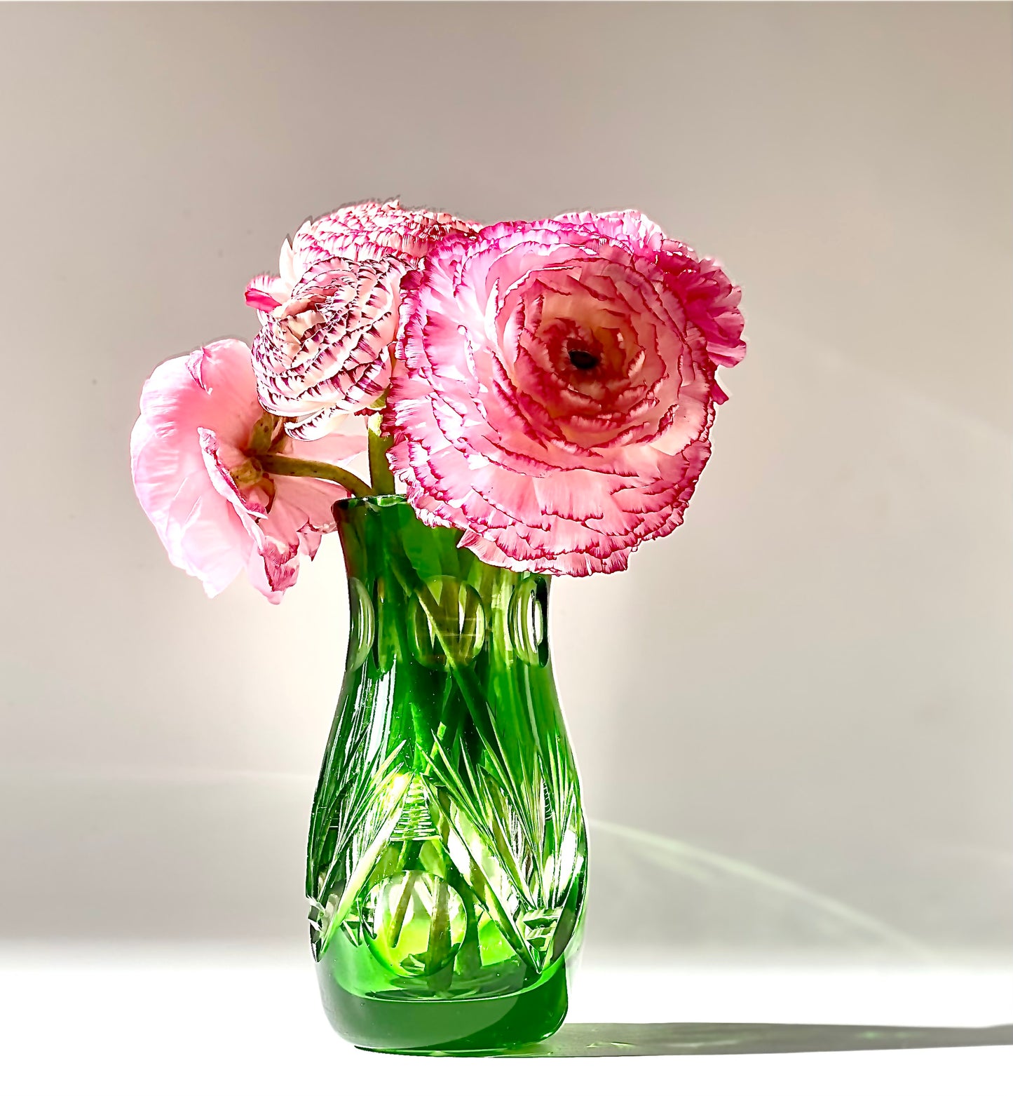 An emerald green crystal cut glass vase .