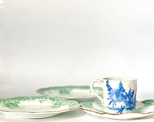 A Chinoiserie set of bone china side plates, a saucer and a cup in a mint green. The plates have scalloped rims with gold lustre edging.