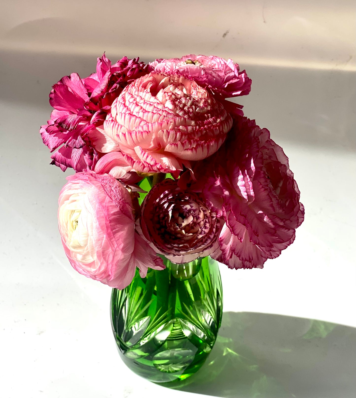 An emerald green crystal cut glass vase .