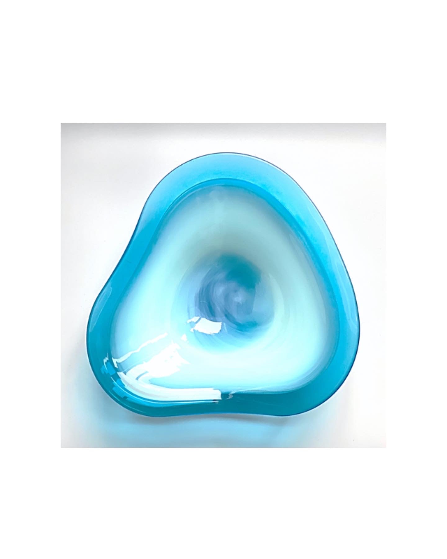 A Murano glass bowl in sky blue with a soft wave and an outer rim in admiral blue.