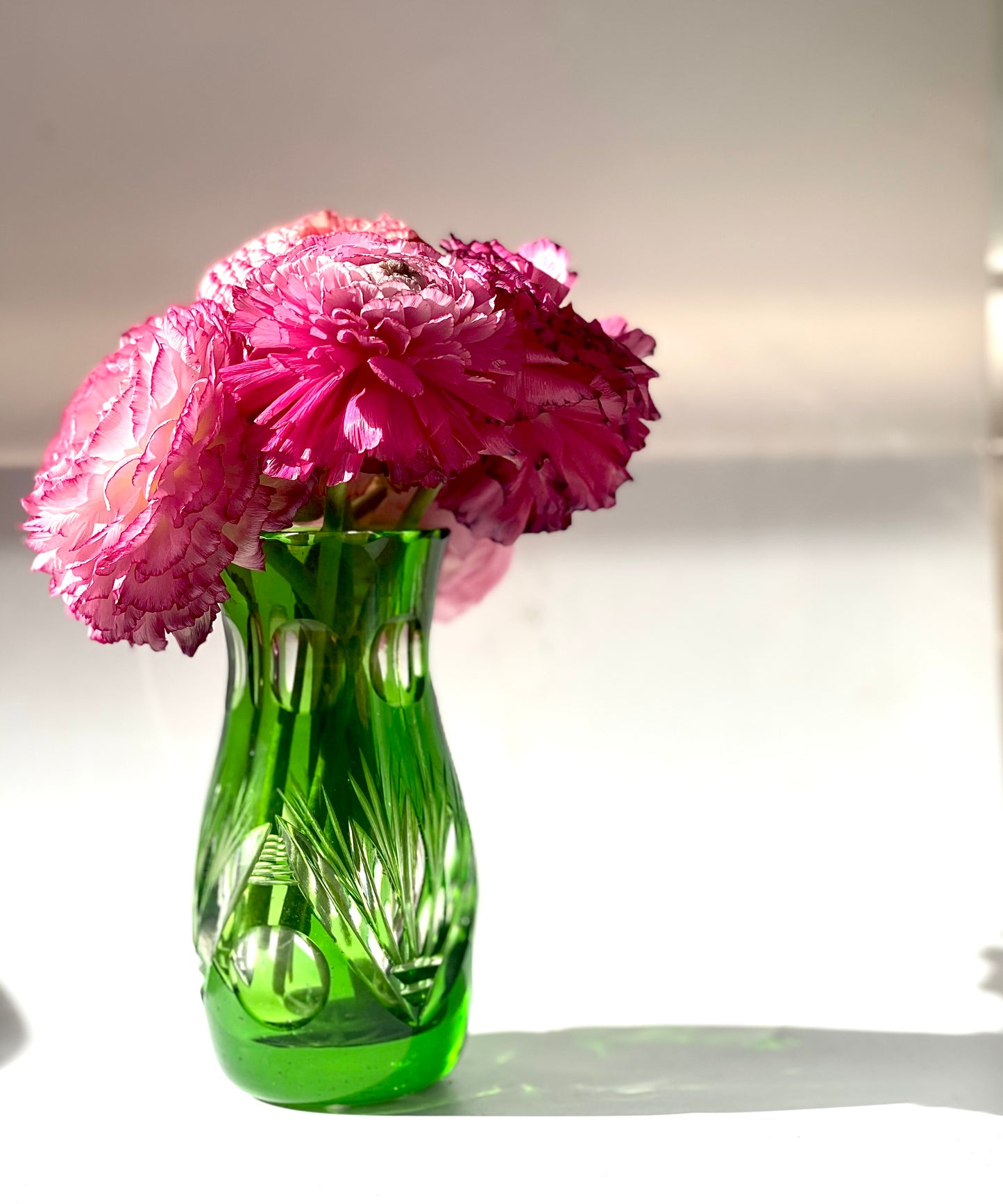 An emerald green crystal cut glass vase .