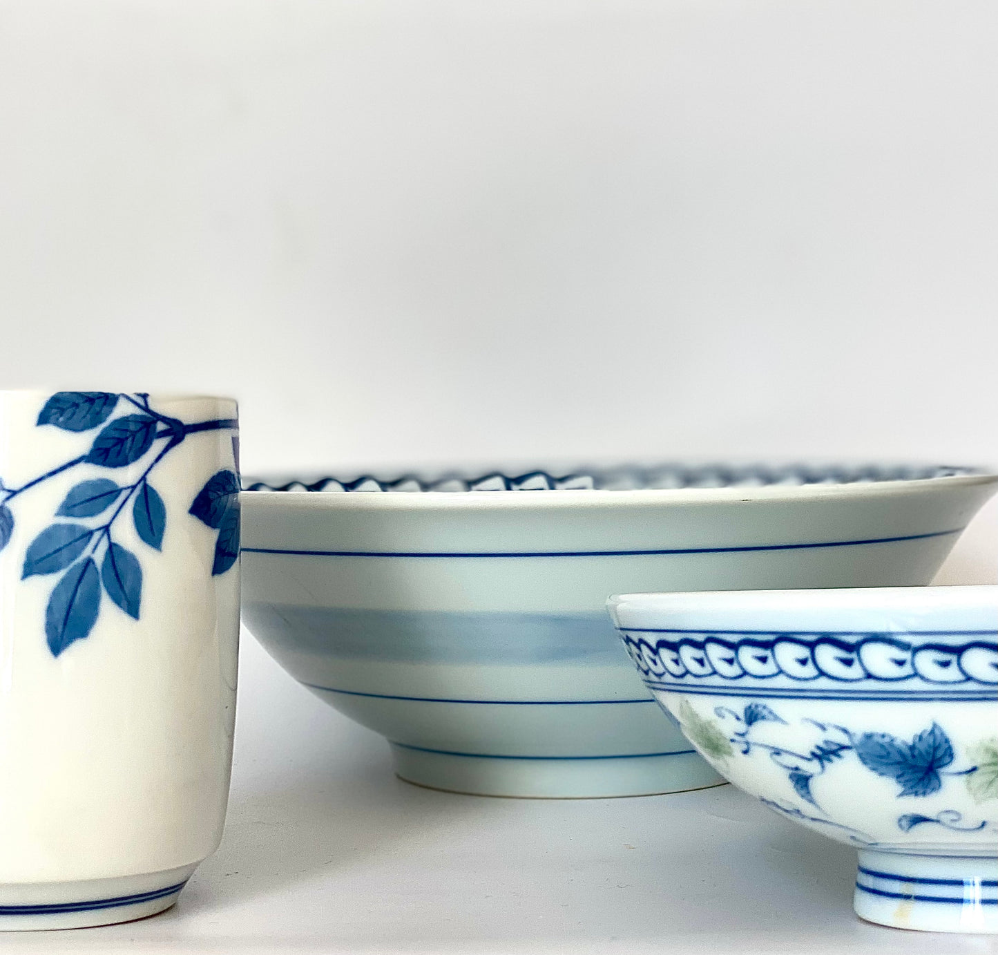 A charming set of blue and white ceramic bowls and a cup.