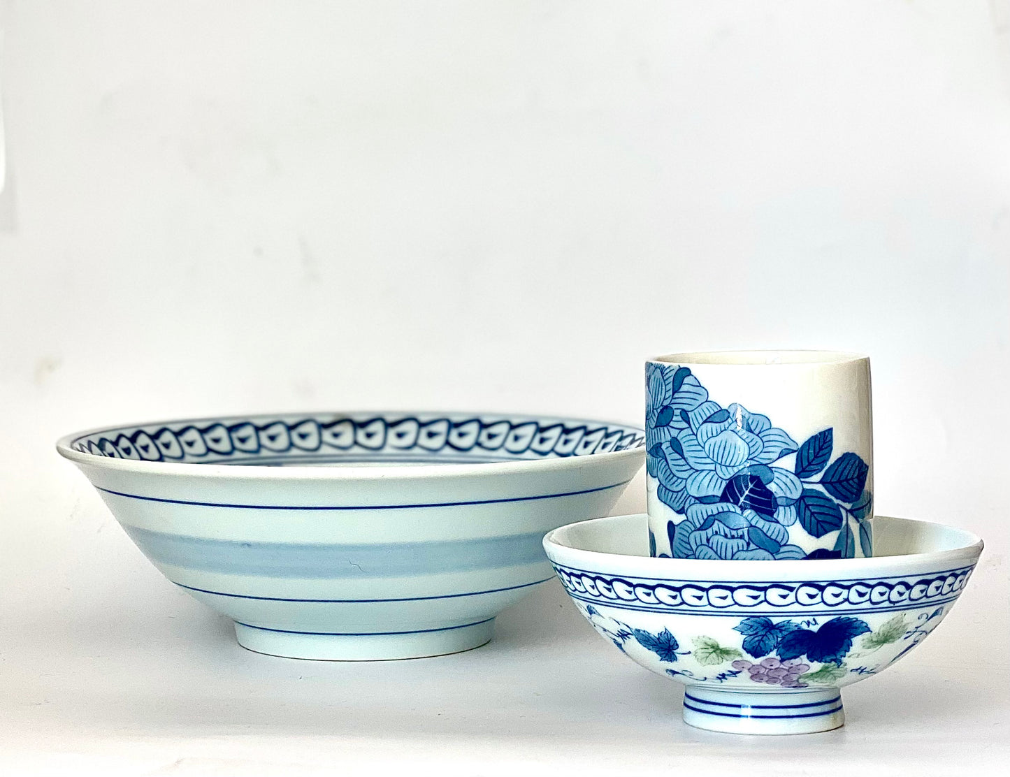 A charming set of blue and white ceramic bowls and a cup.