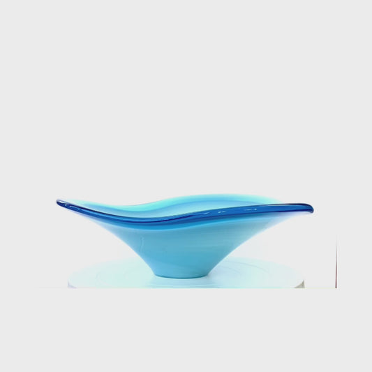 A Murano glass bowl in sky blue with a soft wave and an outer rim in admiral blue.