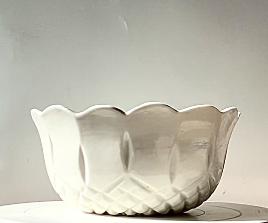 A porcelain bowl with a clear gloss glaze and a scalloped edge.