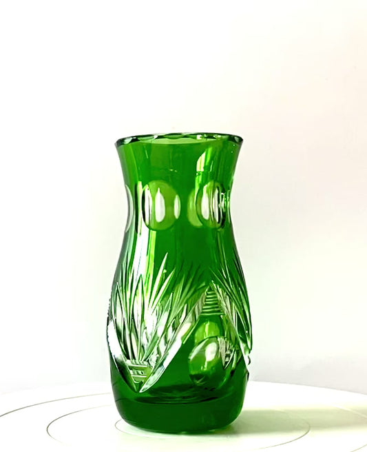 An emerald green crystal cut glass vase .