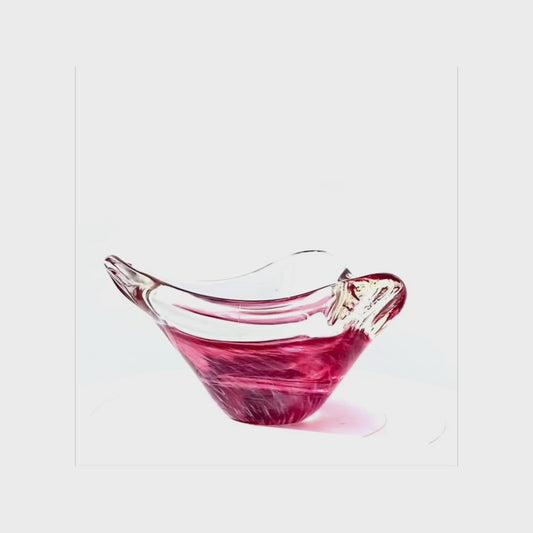 A glass bowl in a mottled fuscia pink.