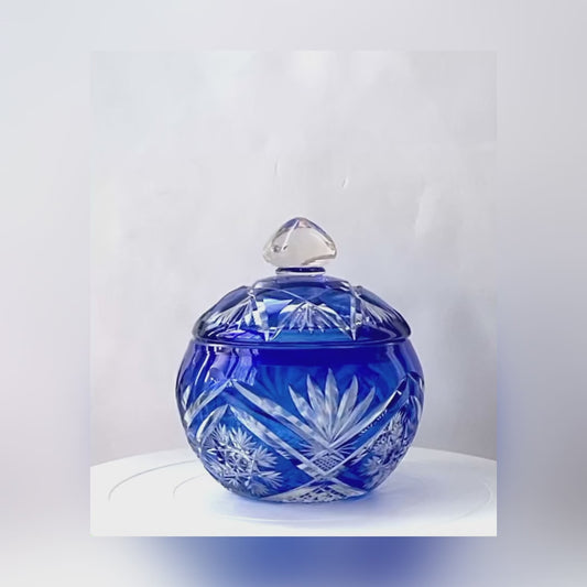 A crystal cut glass lidded bowl in a cobalt sapphire blue.