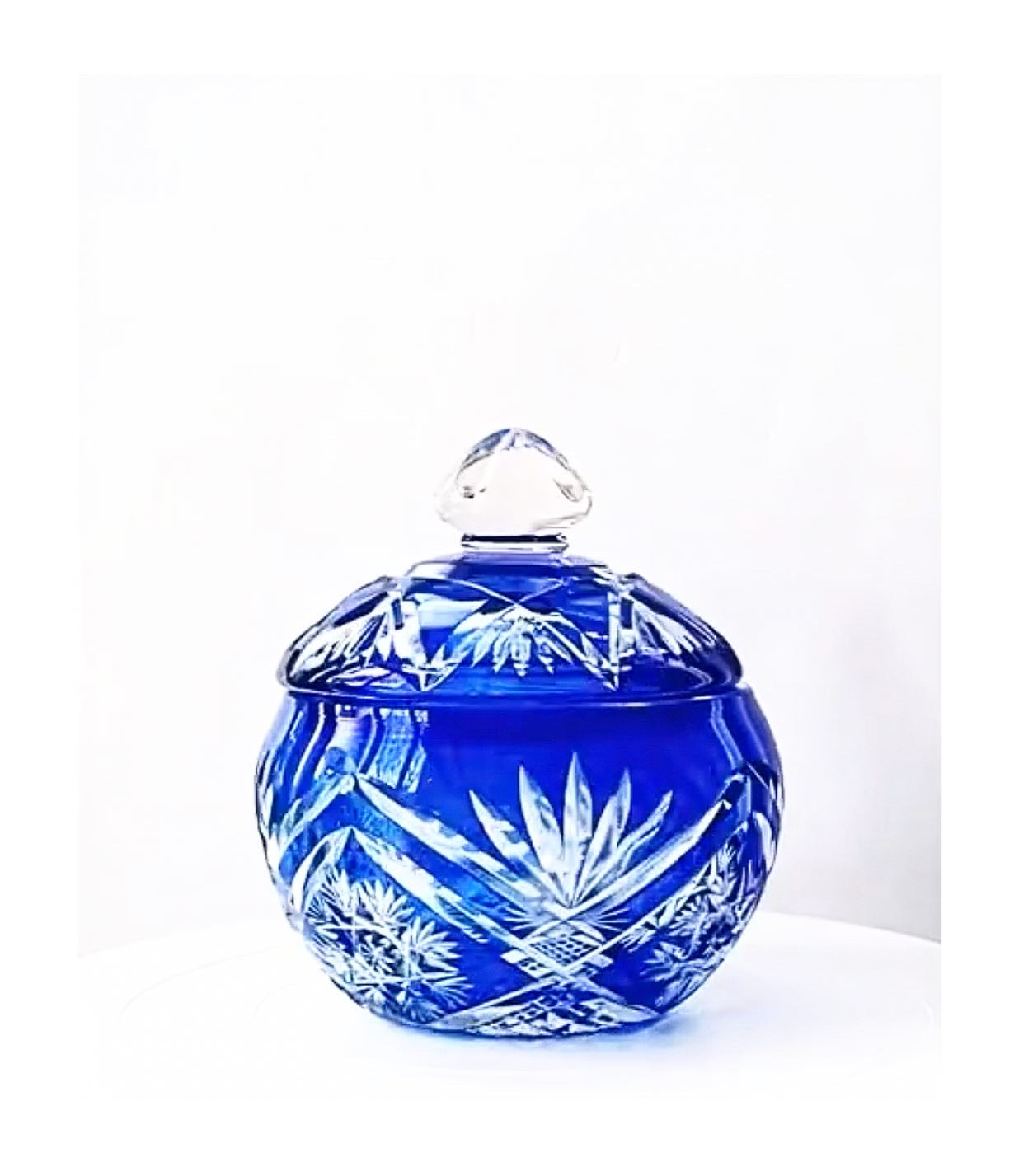 A crystal cut glass lidded bowl in a cobalt sapphire blue.