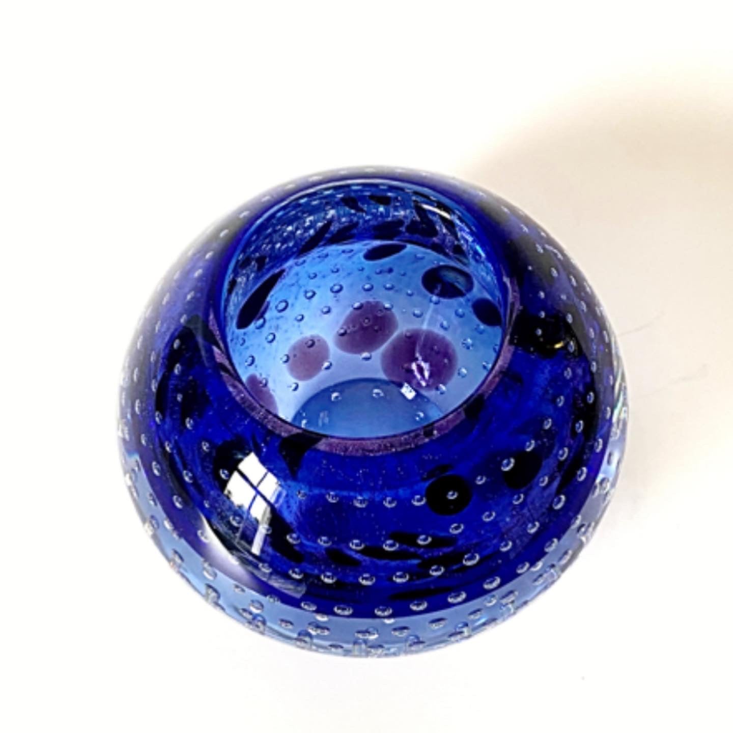 A Murano glass bowl in an inky deep violet with mottled flecks of black.