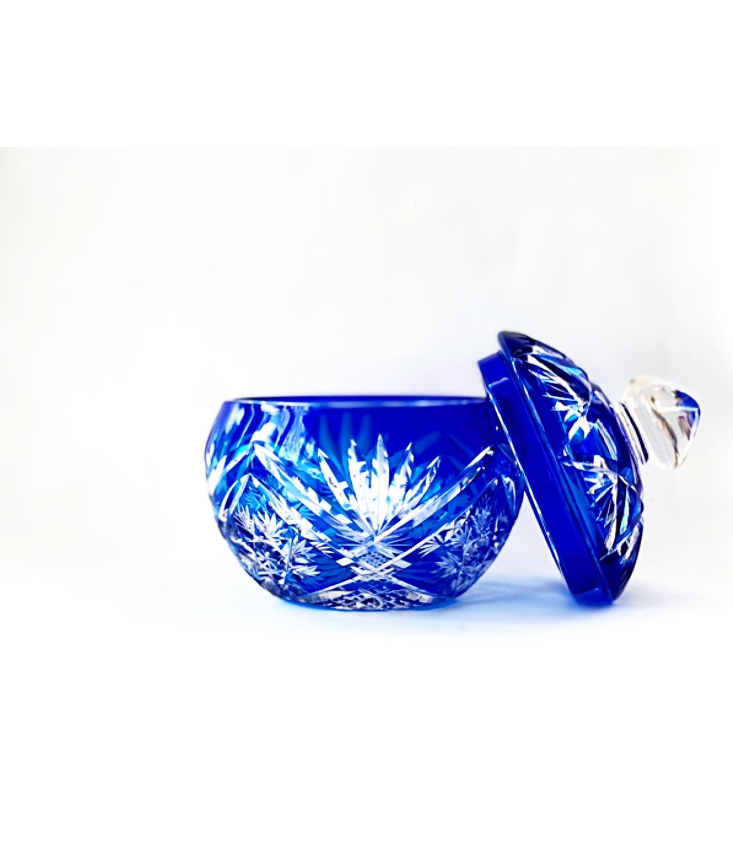 A crystal cut glass lidded bowl in a cobalt sapphire blue.