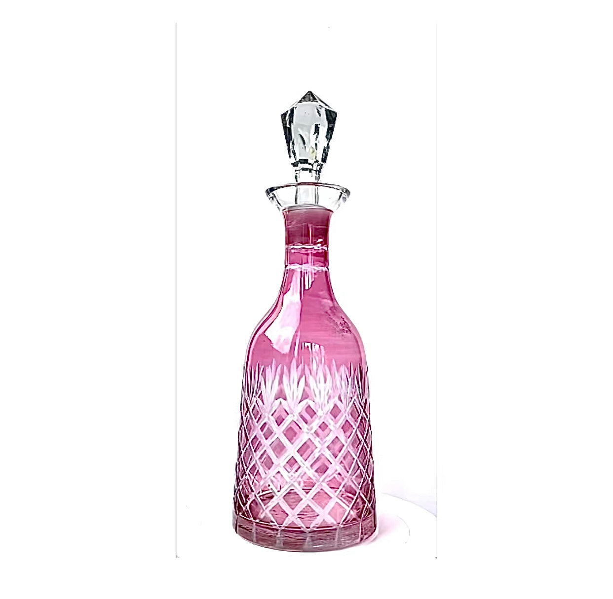 A vintage cranberry pink cut glass decanter