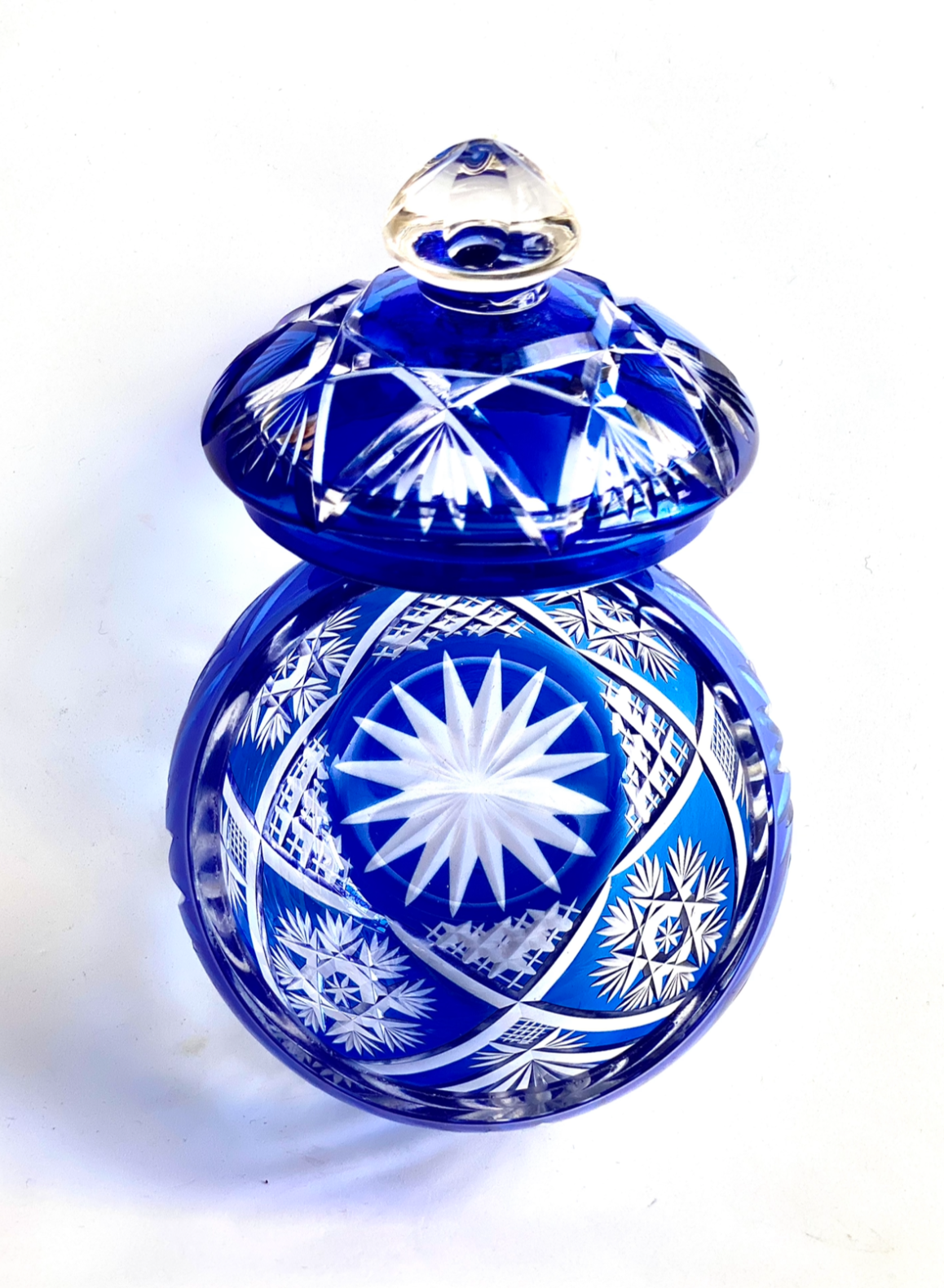 A crystal cut glass lidded bowl in a cobalt sapphire blue.