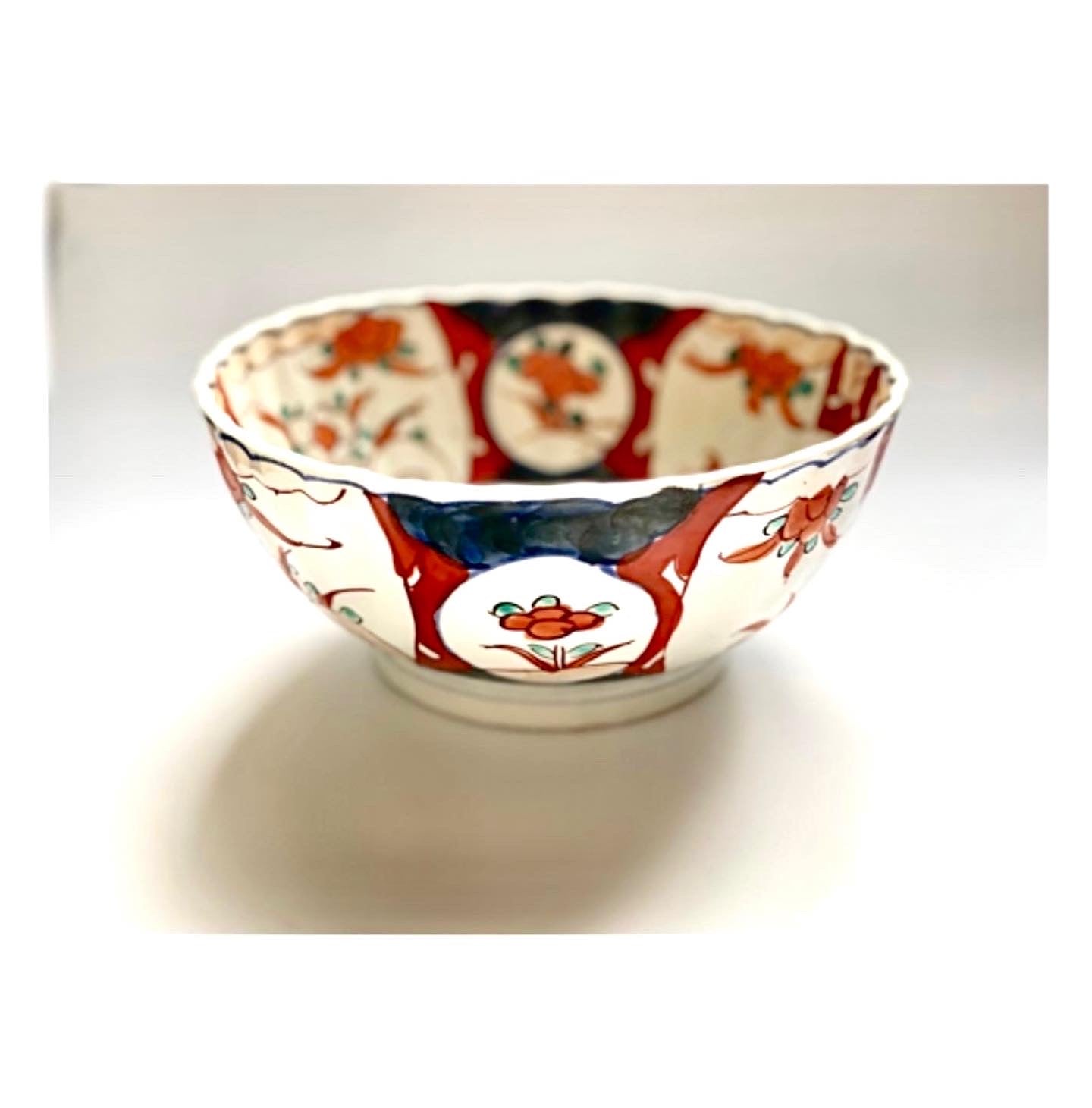 A Japanese ceramic bowl hand painted in manganese, cobalt and red iron oxide.