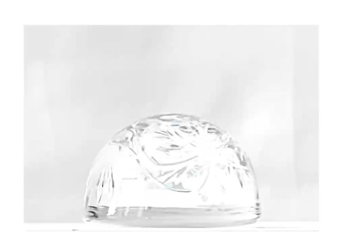 A clear cut engraved glass dome paperweight