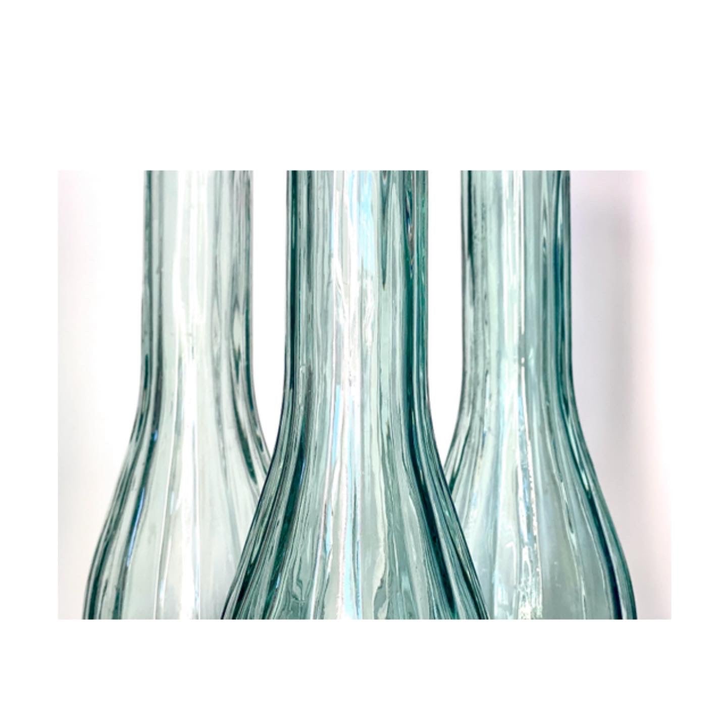 A trio of vintage sage green glass vases or jugs