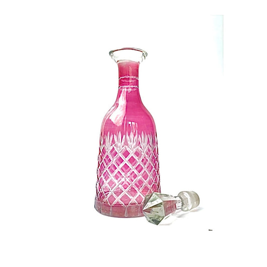 A vintage cranberry pink cut glass decanter